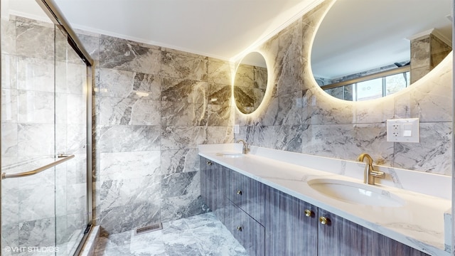 bathroom with vanity, a shower with door, tile walls, and ornamental molding