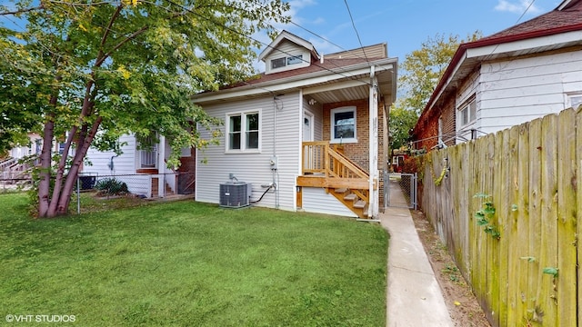 view of front of house featuring central AC unit and a front lawn