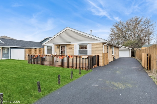 view of front of home featuring a wooden deck, an outbuilding, a front yard, and a garage