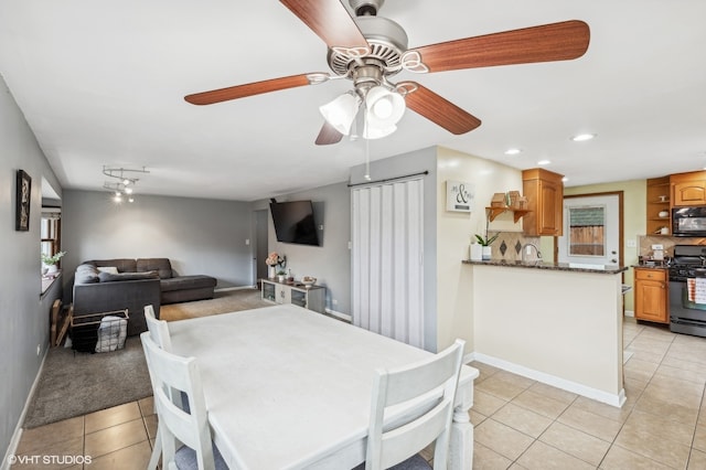 dining space with light tile patterned floors, ceiling fan, and sink