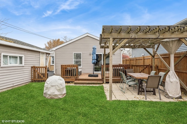 rear view of property with a pergola, a wooden deck, and a yard