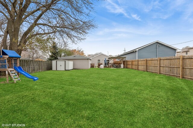 view of yard featuring a storage shed and a playground