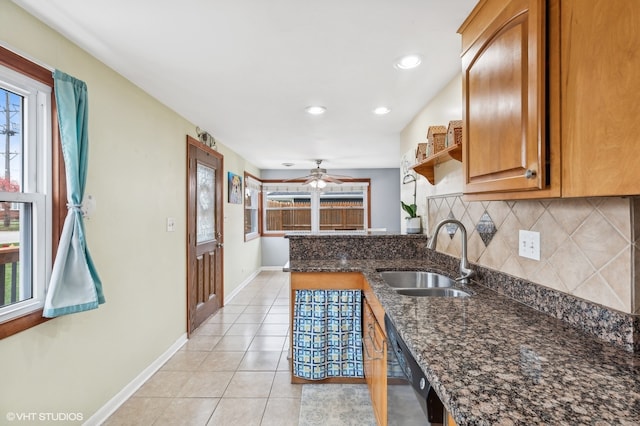 kitchen featuring a wealth of natural light, sink, and dark stone counters