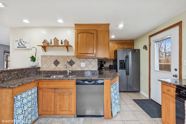 kitchen featuring backsplash, sink, dark stone countertops, appliances with stainless steel finishes, and light tile patterned flooring