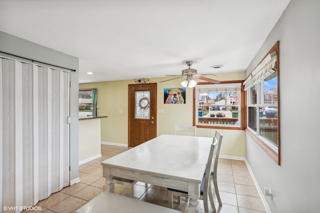 tiled dining room featuring ceiling fan and a healthy amount of sunlight