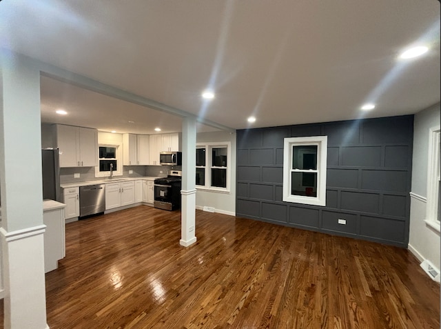 unfurnished living room with dark wood-type flooring