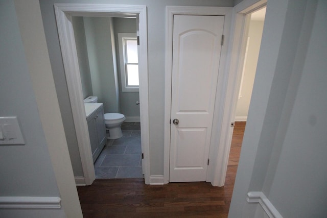 bathroom featuring wood-type flooring, vanity, and toilet