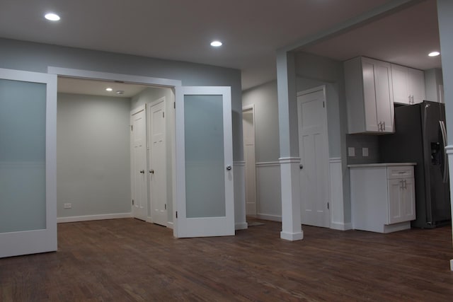 kitchen featuring white cabinets, decorative backsplash, dark wood-type flooring, and refrigerator with ice dispenser