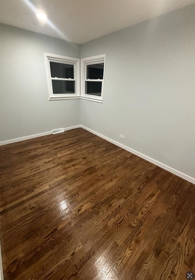 spare room with dark wood-type flooring