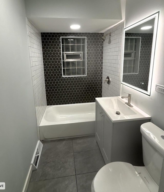 full bathroom featuring tile patterned floors, vanity, toilet, and tiled shower / bath