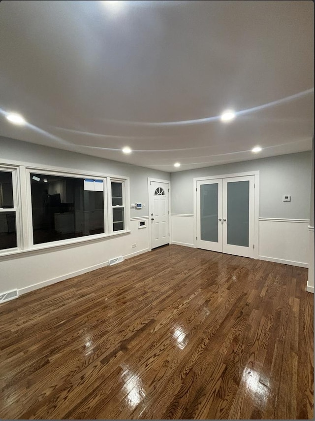 unfurnished living room with french doors and dark wood-type flooring