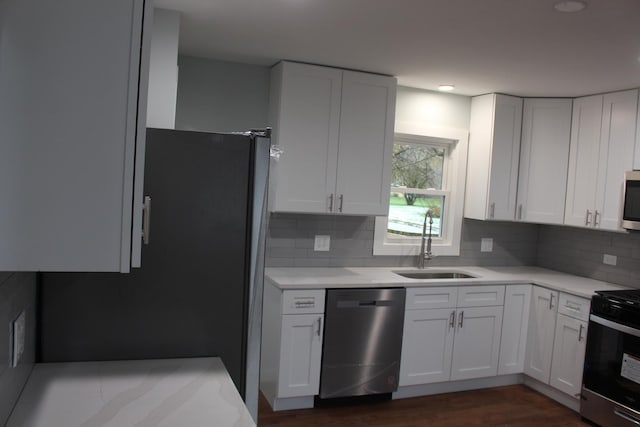 kitchen featuring decorative backsplash, white cabinetry, stove, and sink