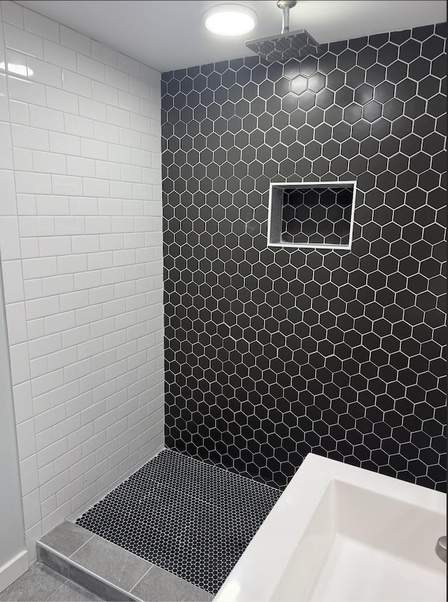 bathroom with tile patterned flooring and tiled shower