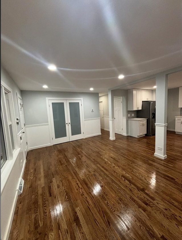 unfurnished living room with dark hardwood / wood-style flooring and french doors