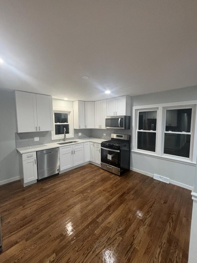 kitchen featuring white cabinetry, sink, appliances with stainless steel finishes, and tasteful backsplash