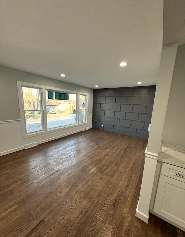 unfurnished living room with dark hardwood / wood-style flooring