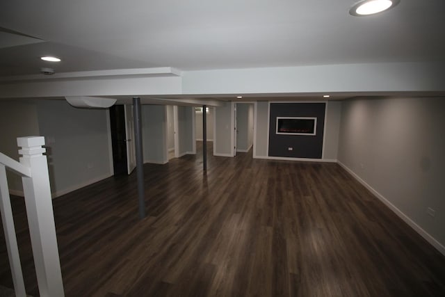 basement with dark hardwood / wood-style floors and a fireplace