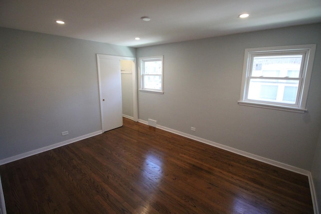 unfurnished room with dark wood-type flooring