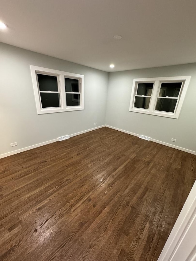 spare room with dark wood-type flooring