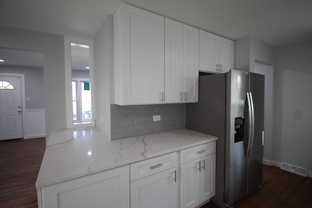 kitchen featuring white cabinetry, backsplash, and light stone countertops