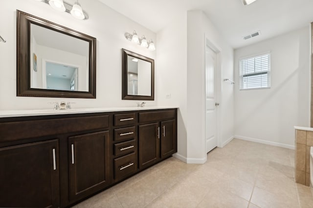 bathroom with tile patterned floors, a tub to relax in, and vanity