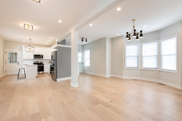 kitchen with white cabinetry, a wealth of natural light, pendant lighting, and appliances with stainless steel finishes