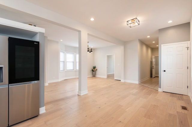 interior space featuring light hardwood / wood-style floors and a notable chandelier