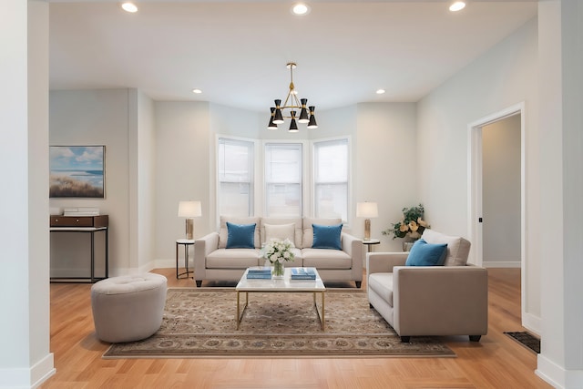 living room featuring a notable chandelier and light wood-type flooring