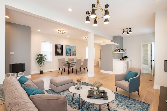 living room with light wood-type flooring and a chandelier