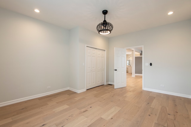 unfurnished bedroom with light hardwood / wood-style flooring and a closet