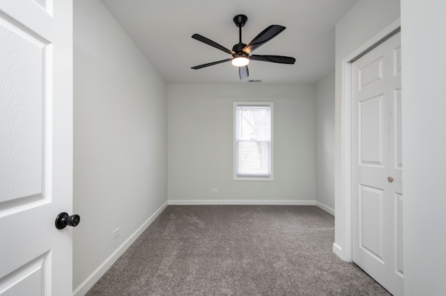 carpeted spare room with ceiling fan