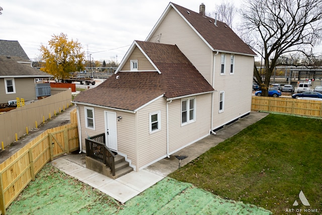 rear view of property with a lawn