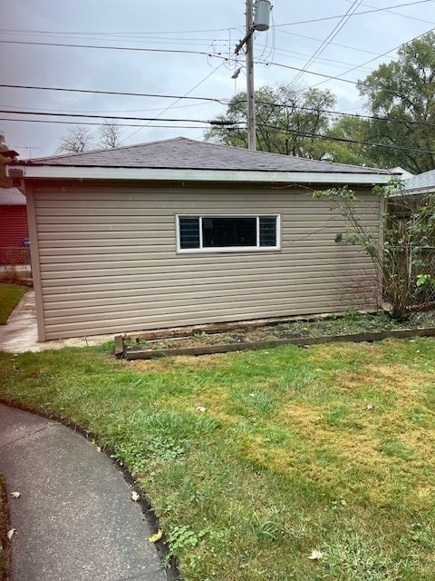 view of property exterior with a lawn and an outbuilding