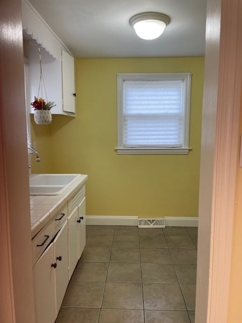 laundry room with light tile patterned floors and sink