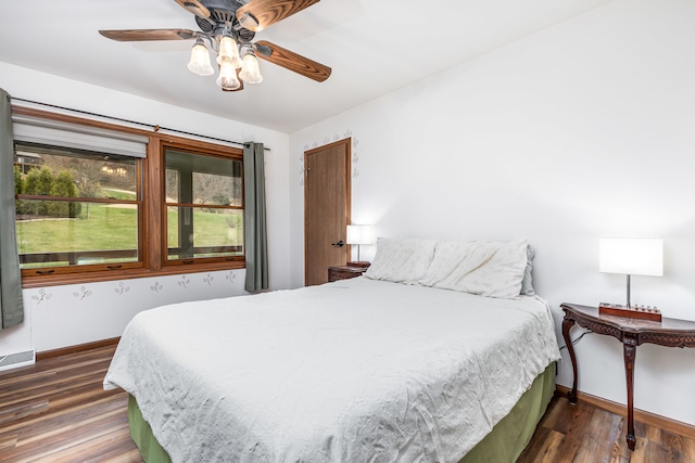 bedroom with ceiling fan and dark wood-type flooring