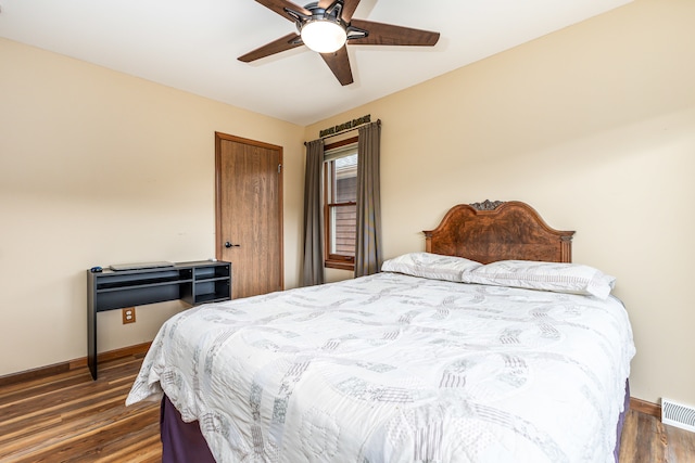 bedroom with dark hardwood / wood-style floors and ceiling fan