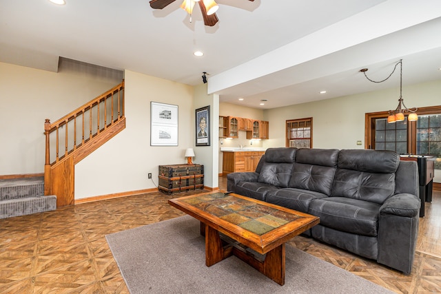 living room with ceiling fan with notable chandelier and parquet floors