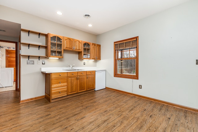 kitchen featuring white dishwasher, hardwood / wood-style flooring, and sink