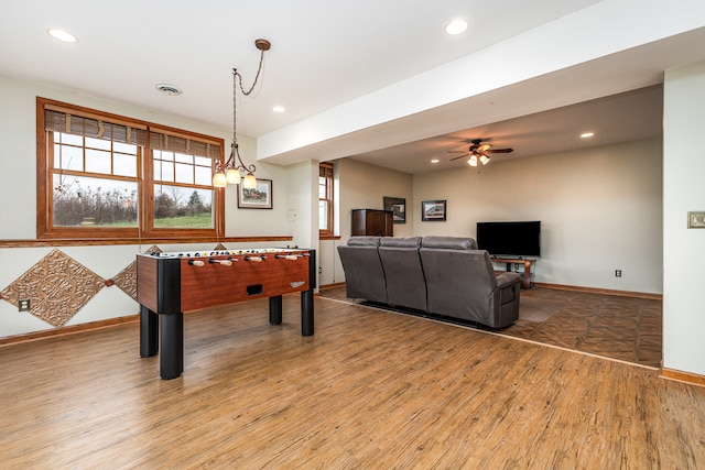 rec room featuring ceiling fan with notable chandelier and hardwood / wood-style flooring