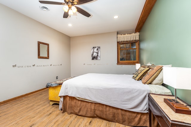 bedroom featuring beamed ceiling, light hardwood / wood-style flooring, and ceiling fan