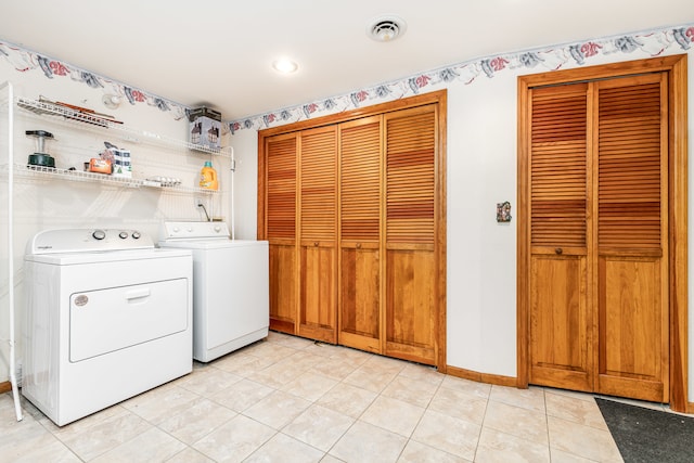 laundry room with independent washer and dryer and light tile patterned flooring