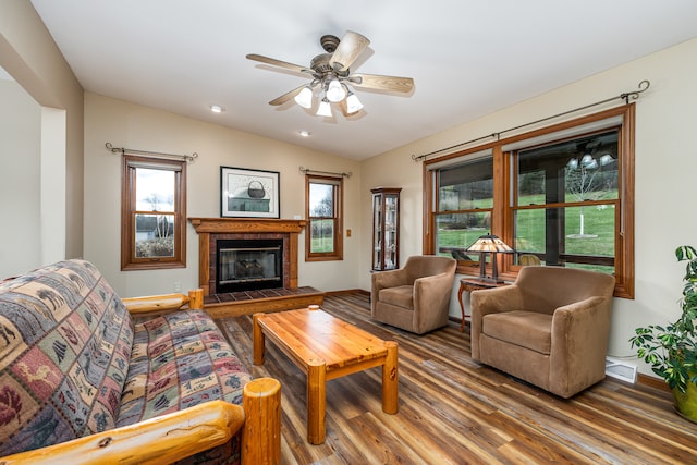 living room with hardwood / wood-style floors, ceiling fan, lofted ceiling, and a fireplace