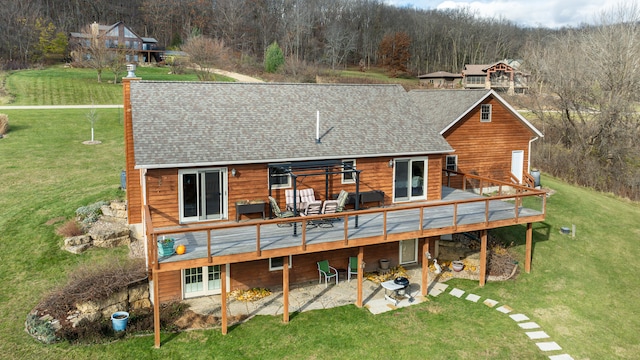 rear view of house featuring a wooden deck and a yard