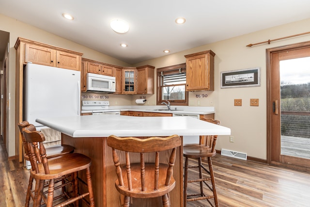 kitchen featuring white appliances, light hardwood / wood-style floors, and plenty of natural light