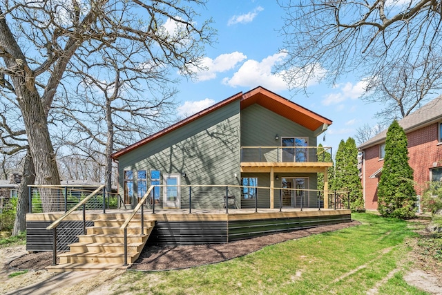 back of house featuring a lawn, a balcony, and a deck