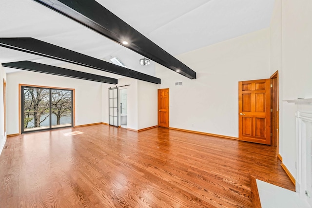 unfurnished living room with vaulted ceiling with beams and hardwood / wood-style flooring