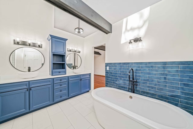 bathroom with beam ceiling, vanity, a tub to relax in, and tile patterned floors