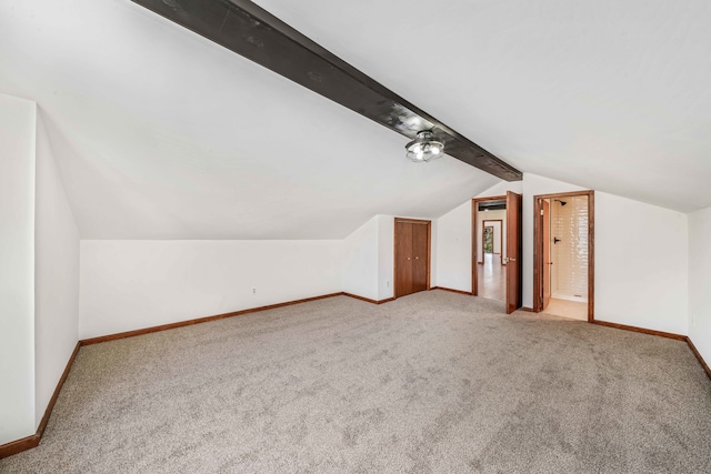 additional living space with vaulted ceiling with beams and carpet floors