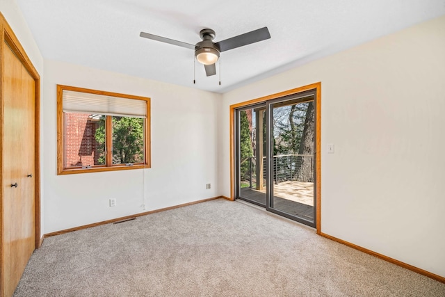 empty room with ceiling fan and light colored carpet