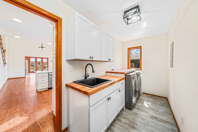 kitchen with white cabinetry, butcher block counters, and sink